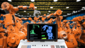 operating orange robotic arms via a laptop in a manufacturing setting